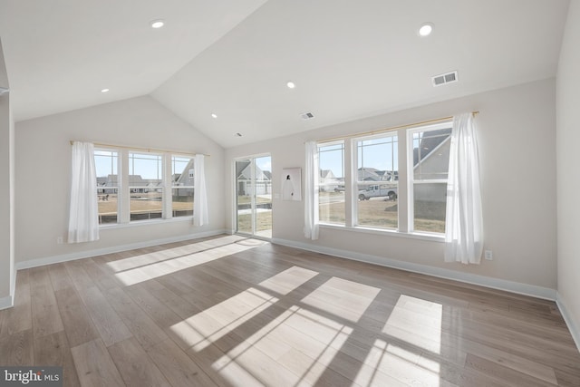 unfurnished living room featuring vaulted ceiling and light hardwood / wood-style flooring