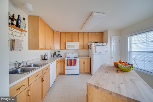 kitchen with white appliances, light brown cabinetry, sink, and butcher block countertops