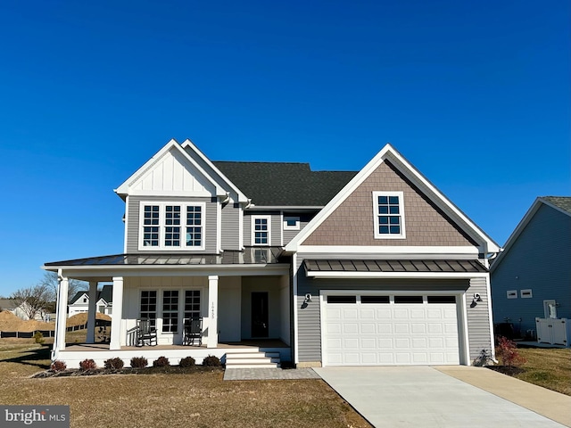 view of front facade with a porch, a garage, and a front yard