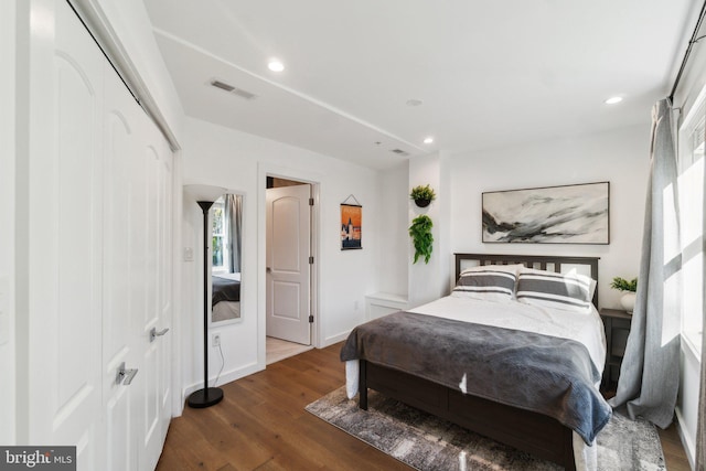 bedroom with a closet and dark hardwood / wood-style floors