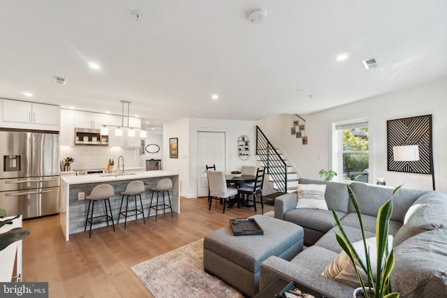 living room with sink and light hardwood / wood-style floors