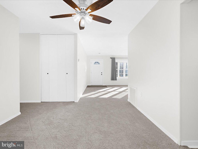 unfurnished room with light colored carpet and ceiling fan