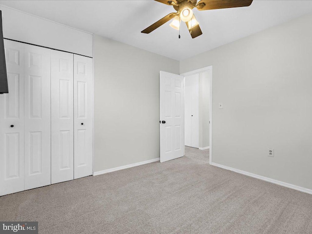 unfurnished bedroom with ceiling fan, a closet, and light carpet