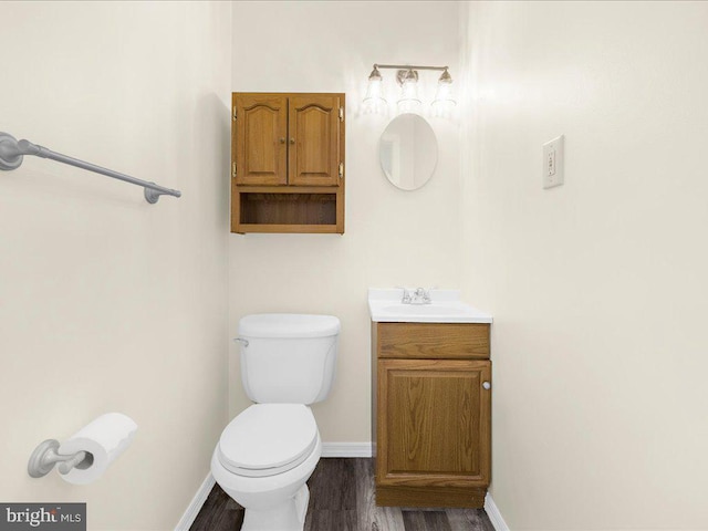 bathroom with vanity, toilet, and wood-type flooring