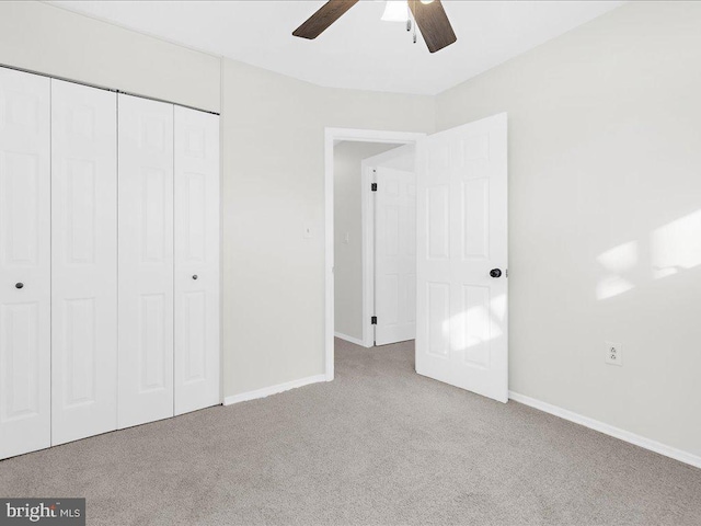 unfurnished bedroom with light carpet, a closet, and ceiling fan