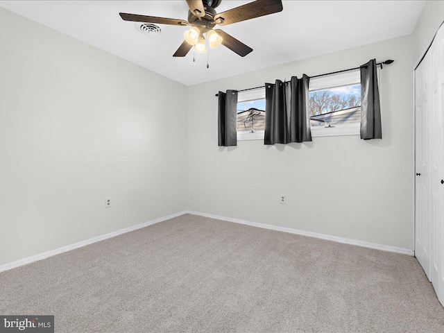 carpeted spare room with ceiling fan