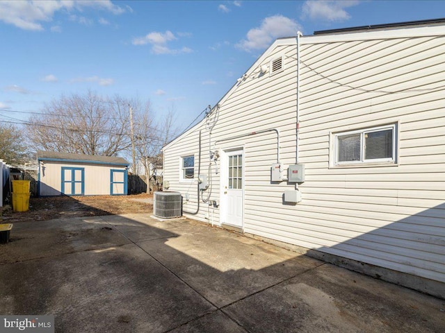 back of house featuring a shed, cooling unit, and a patio area