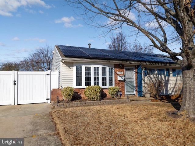 view of front of property featuring a front yard and solar panels