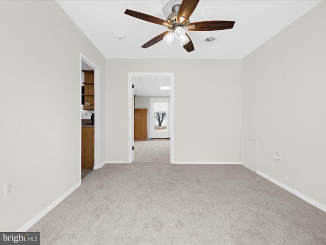 spare room with a paneled ceiling, light colored carpet, and ceiling fan