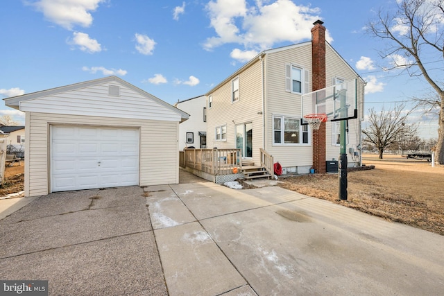 back of property featuring central AC, a garage, and an outdoor structure