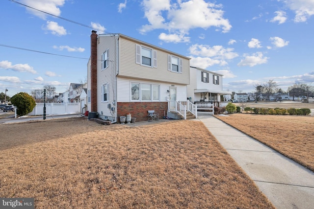 front of property with cooling unit and a front lawn