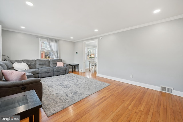 living room featuring ornamental molding and light wood-type flooring