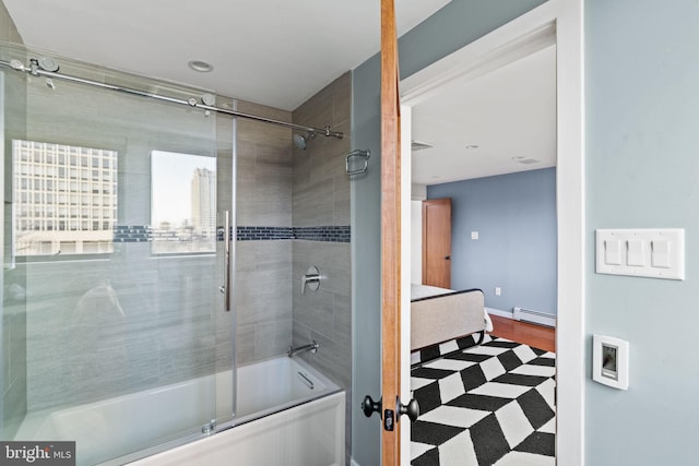 bathroom with combined bath / shower with glass door and a baseboard heating unit