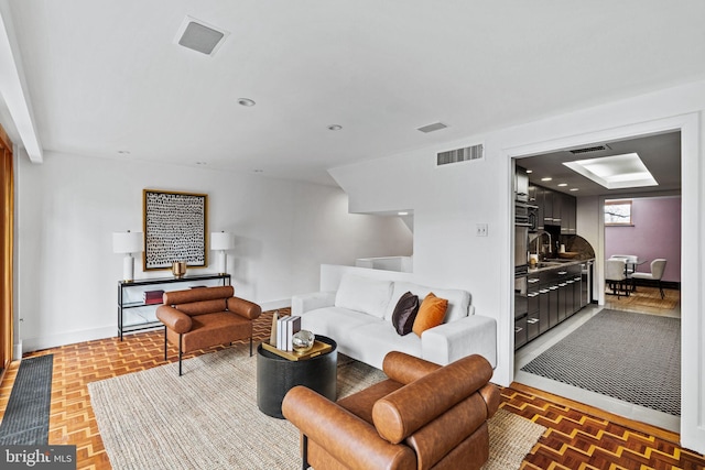 living room with parquet floors and sink