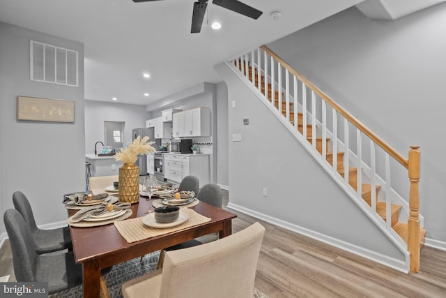 dining space featuring sink, ceiling fan, and light wood-type flooring