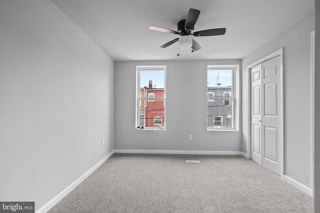 unfurnished room with carpet and ceiling fan