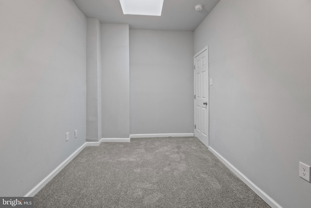 spare room featuring carpet floors and a skylight