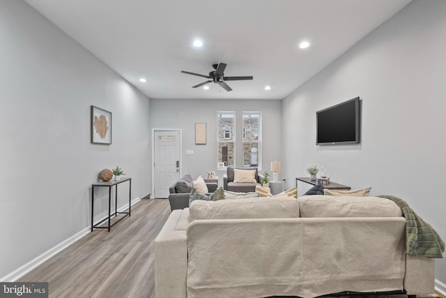 living room featuring light hardwood / wood-style flooring and ceiling fan