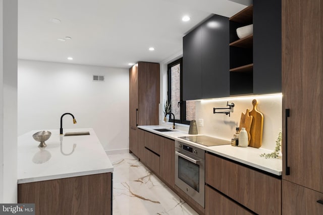 kitchen featuring black electric stovetop, sink, and stainless steel oven