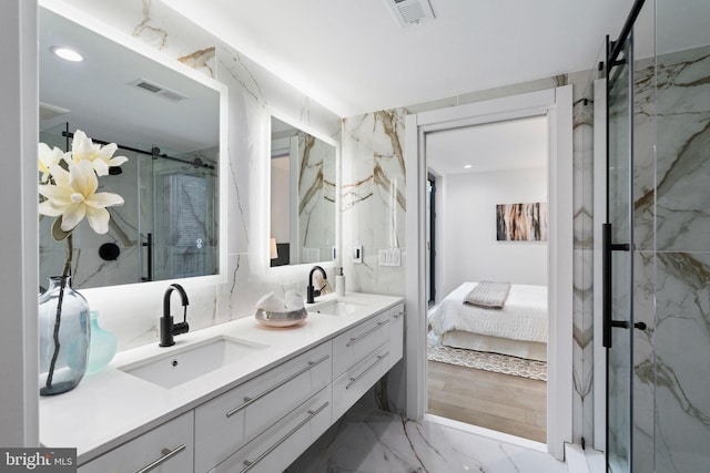 bathroom featuring a shower with door and vanity