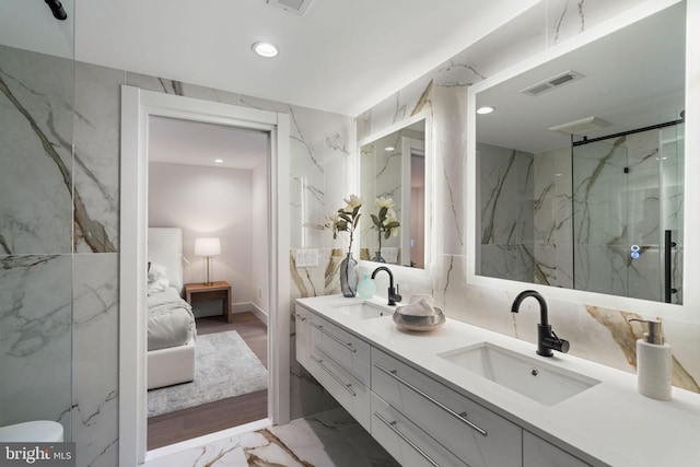 bathroom with vanity, tile walls, and walk in shower