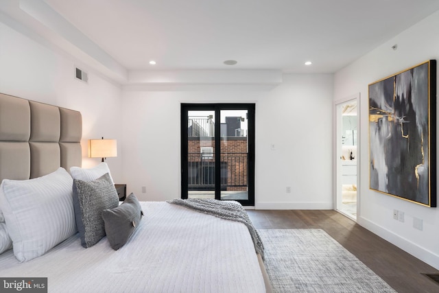 bedroom with connected bathroom, dark hardwood / wood-style floors, and access to outside