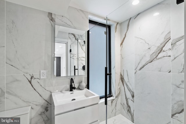 bathroom featuring vanity and tile walls