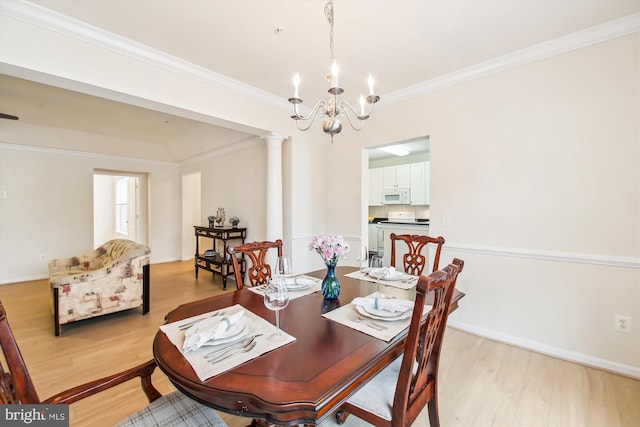 dining area featuring decorative columns, ornamental molding, an inviting chandelier, and light wood-type flooring