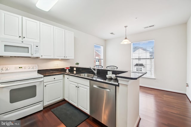 kitchen featuring white cabinetry, white appliances, kitchen peninsula, and sink