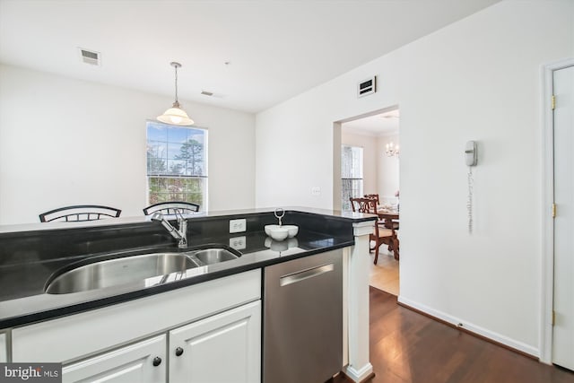 kitchen featuring decorative light fixtures, white cabinetry, dishwasher, sink, and dark wood-type flooring