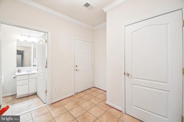 hall with light tile patterned flooring and ornamental molding