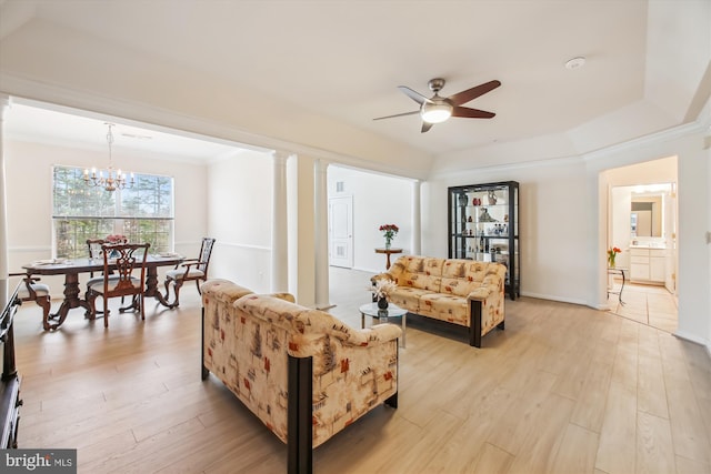 living room with decorative columns, ornamental molding, ceiling fan with notable chandelier, and light hardwood / wood-style flooring