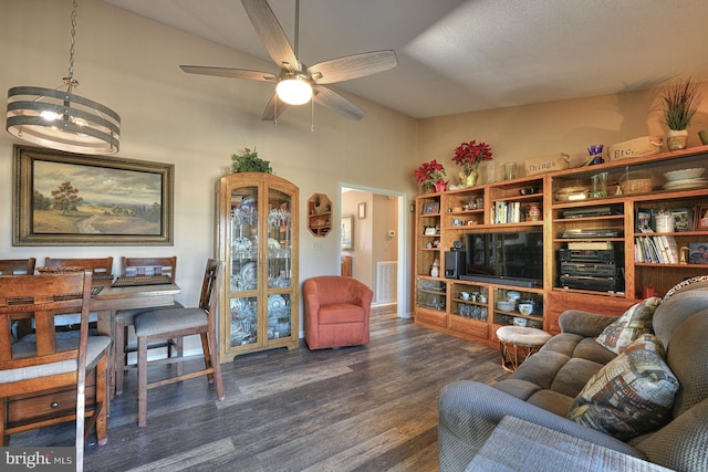 living room with dark hardwood / wood-style flooring and ceiling fan with notable chandelier