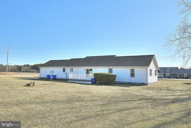 rear view of house featuring a lawn and a deck