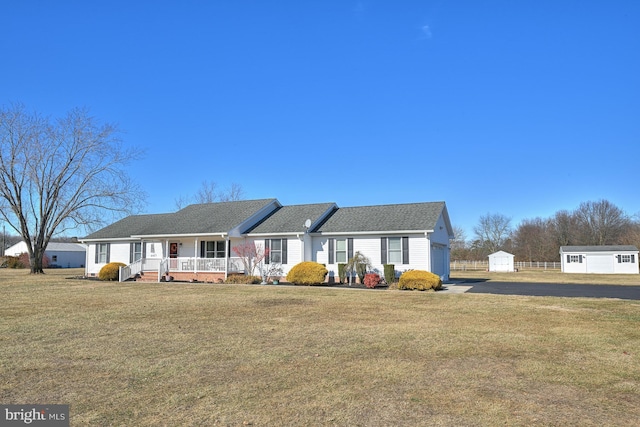 ranch-style house with a front lawn, covered porch, and a storage unit