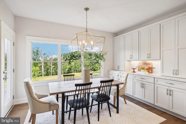 dining room with dark wood-type flooring, a chandelier, and a healthy amount of sunlight