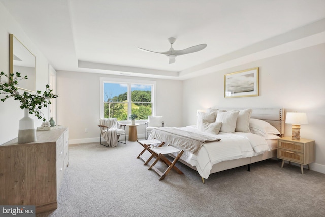 bedroom featuring ceiling fan, carpet flooring, and a raised ceiling