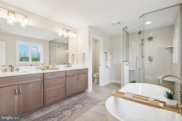 full bathroom featuring toilet, vanity, plus walk in shower, and hardwood / wood-style floors