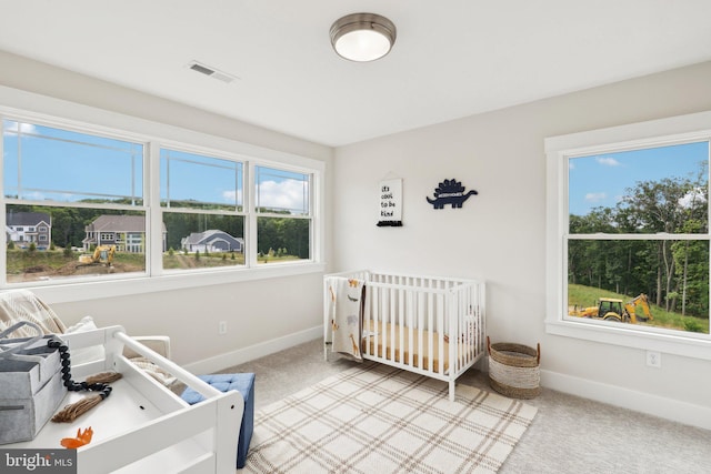 carpeted bedroom with a nursery area