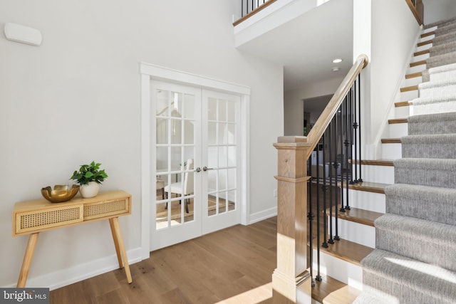 staircase featuring hardwood / wood-style floors and french doors