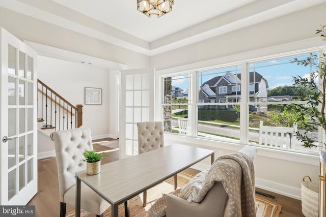 dining space featuring hardwood / wood-style flooring and a chandelier