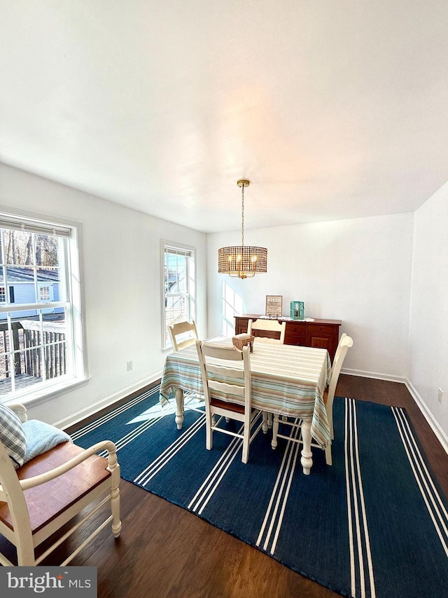 dining area with a notable chandelier and dark hardwood / wood-style flooring