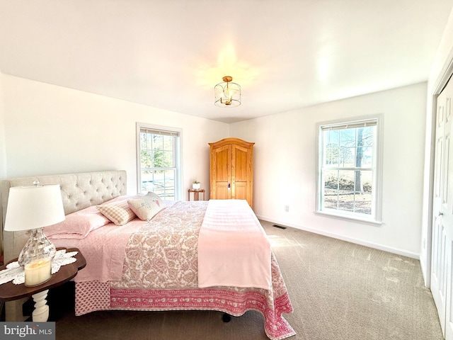 carpeted bedroom with an inviting chandelier