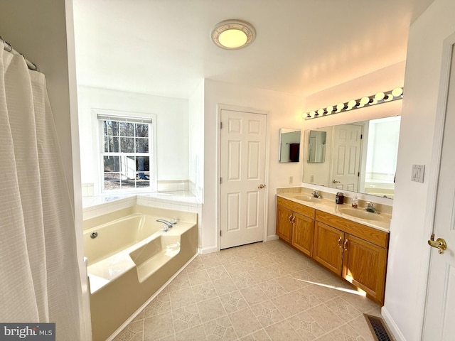 bathroom featuring tile patterned floors, vanity, and a bath