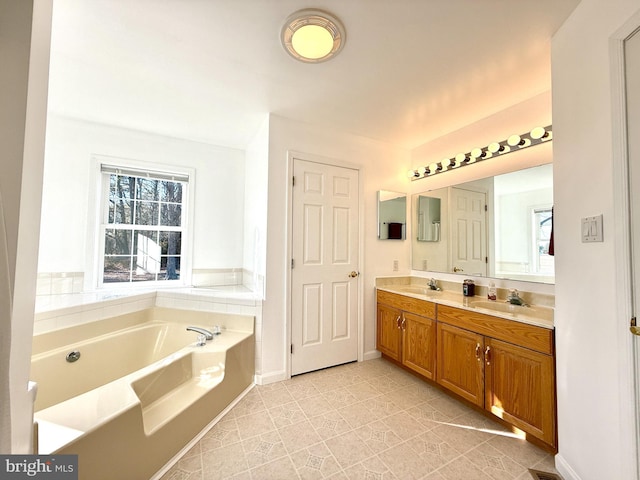 bathroom featuring tile patterned floors, vanity, and a bathing tub