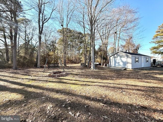 view of yard featuring an outbuilding and a fire pit