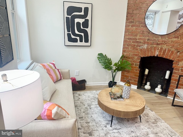 living room with wood-type flooring and a brick fireplace