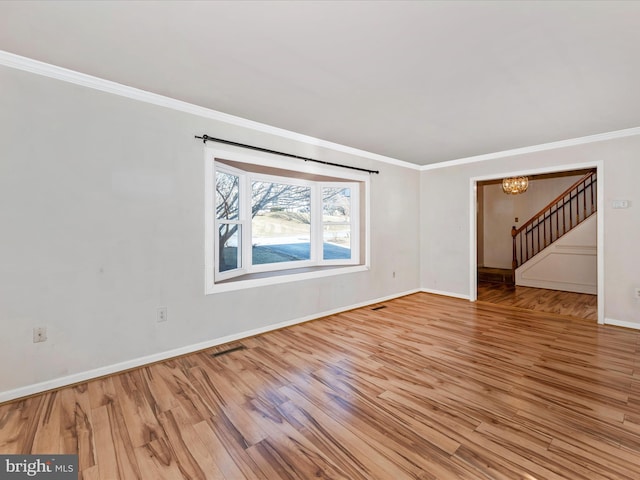 unfurnished room with visible vents, a notable chandelier, crown molding, and light wood-style flooring