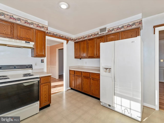 kitchen with visible vents, white appliances, light countertops, and under cabinet range hood