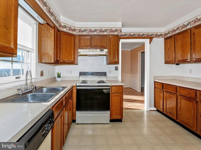 kitchen featuring light countertops, range with electric cooktop, a sink, and under cabinet range hood